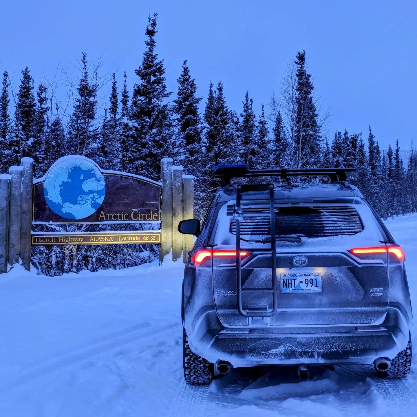 My RAV4 beside the Arctic Circle sign on the Dalton Highway in snowy Alaska
