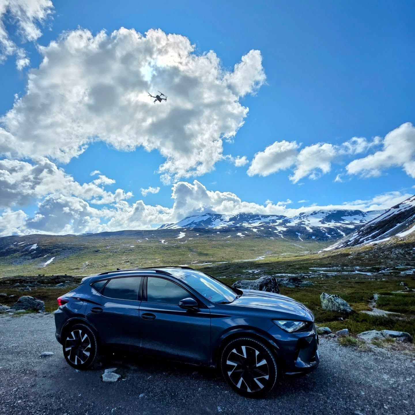 A drone flying above the parked car at Jotunheimen Nasjonalpark, Norway