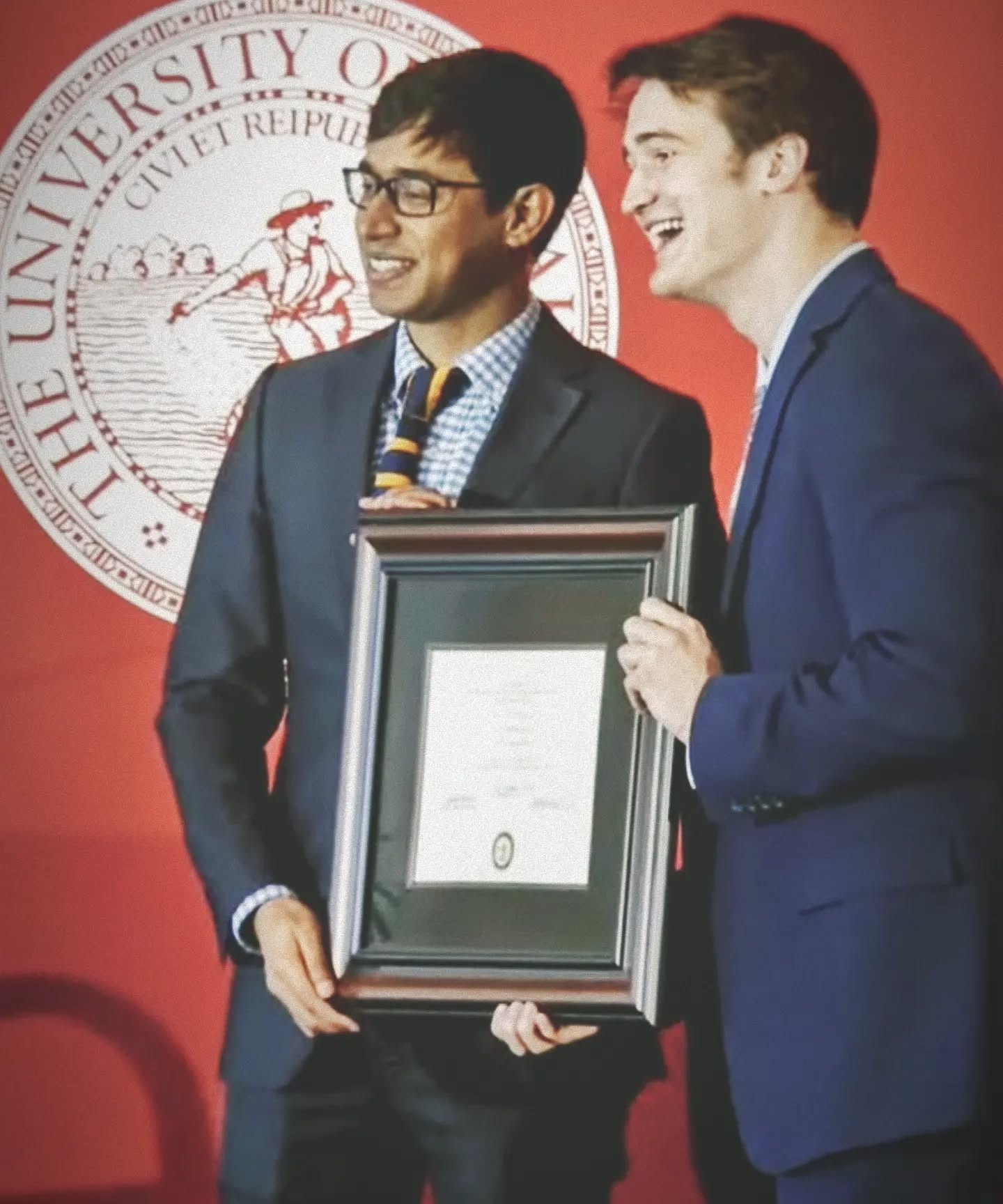 Anindya Maiti holding a framed award at the University of Oklahoma